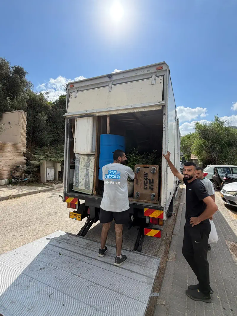 צוות יניב הובלות מעמיס ציוד למשאית במהלך עבודה